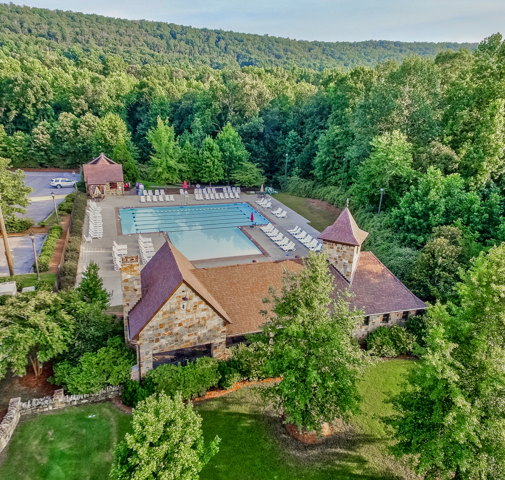 The Ballantrae community swimming pool and stone pool house among trees