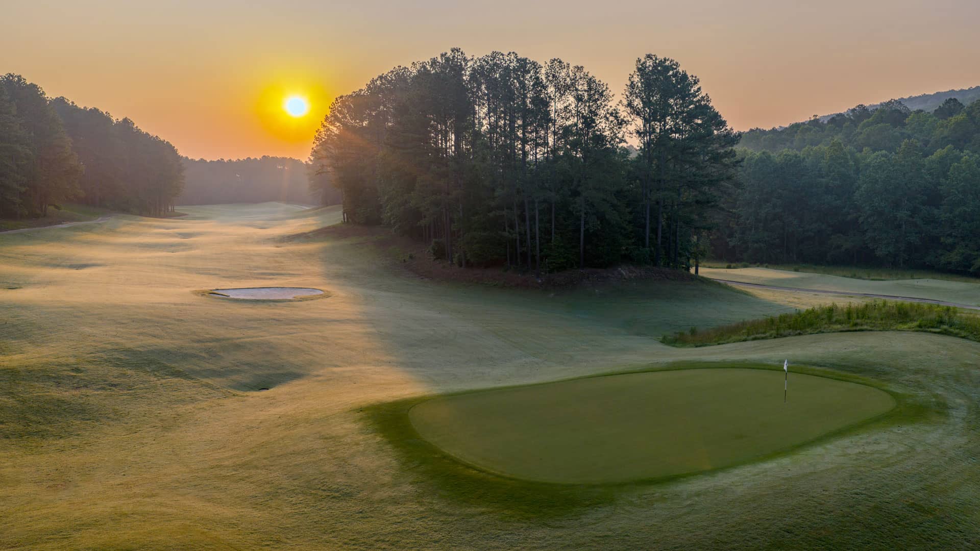 Early morning light over Ballantrae’s wooded landscape and golf green