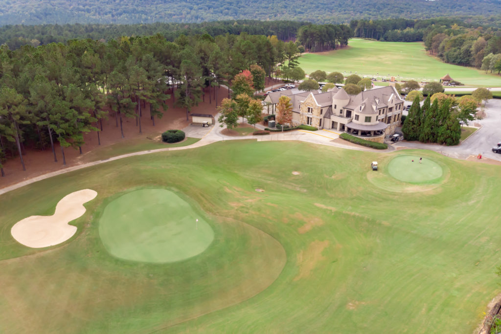 Ballantrae clubhouse and golf greens surrounded by rolling wooded hills